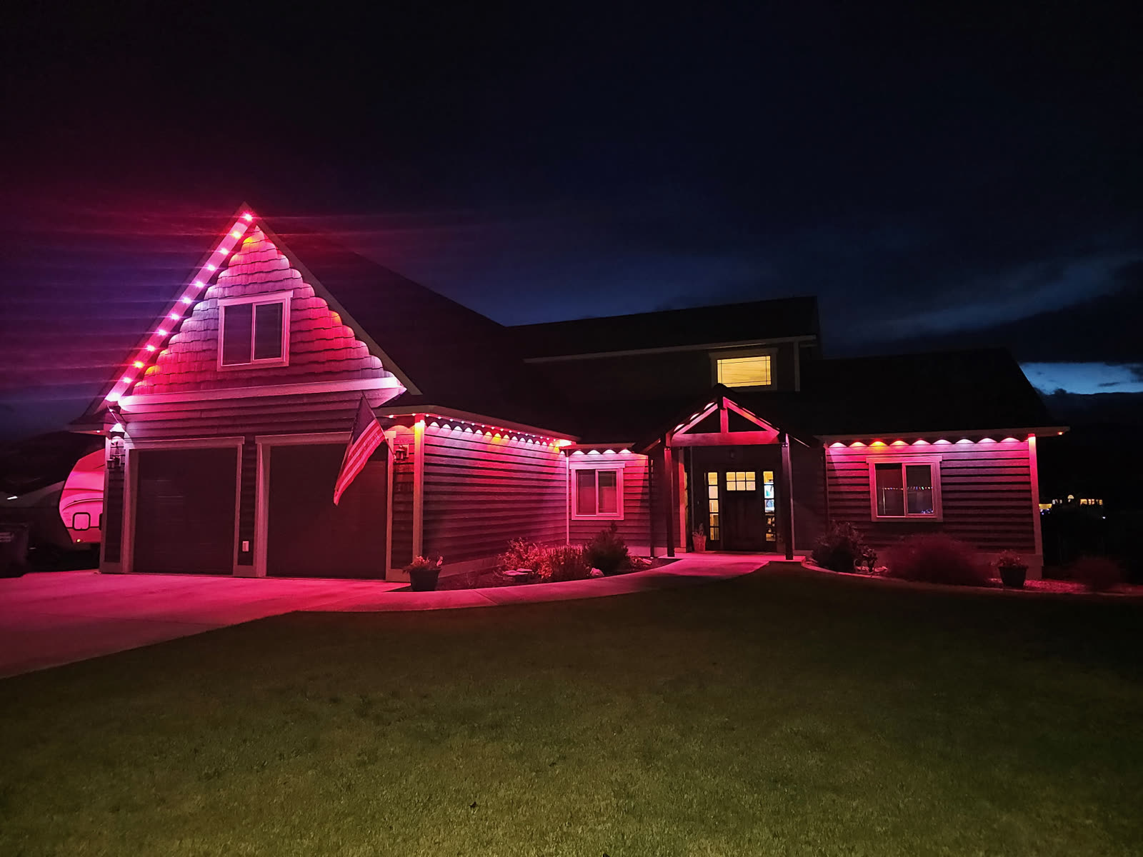 Pink roofline lighting on a two-story home by Montana Lights